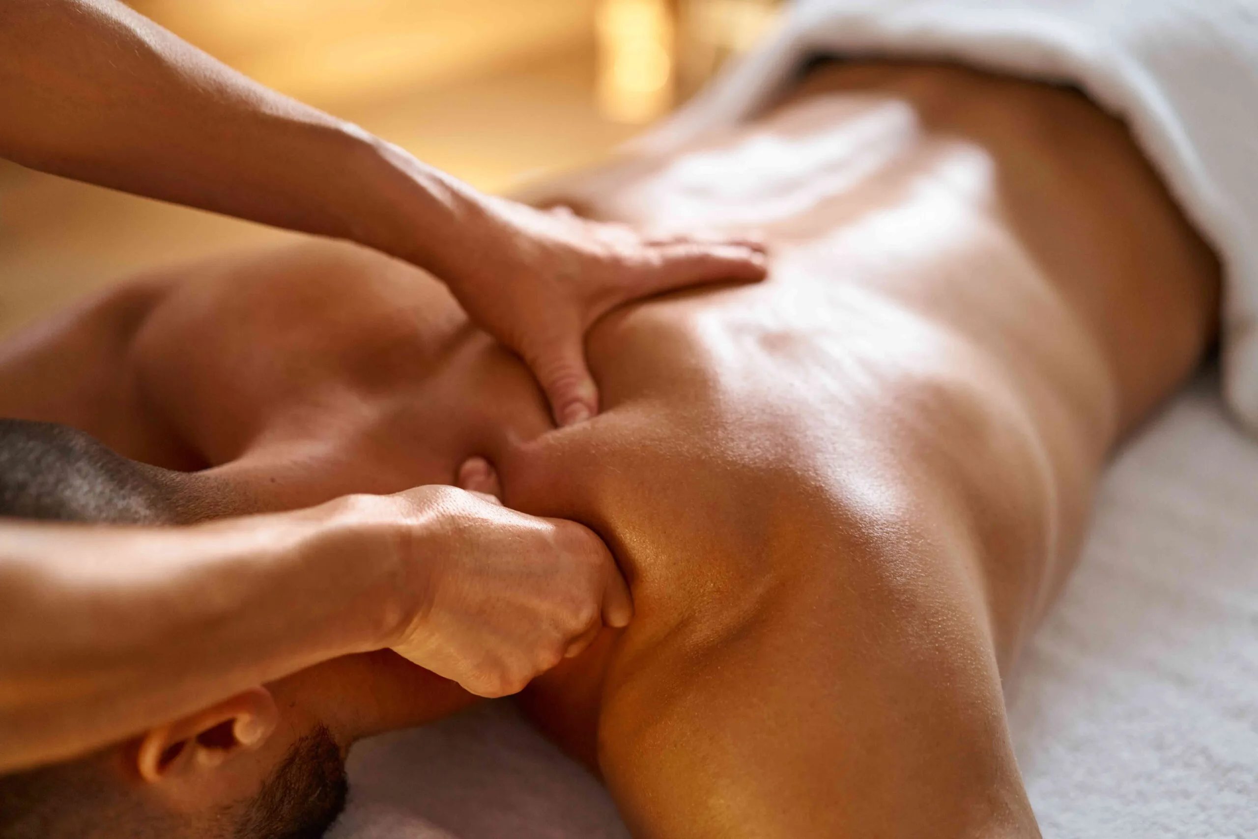 Therapist working on a client's shoulders during a massage
