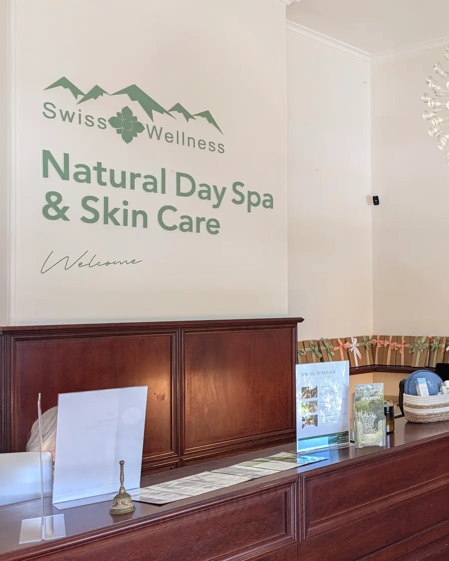Swiss Wellness reception with the green logo on the wall